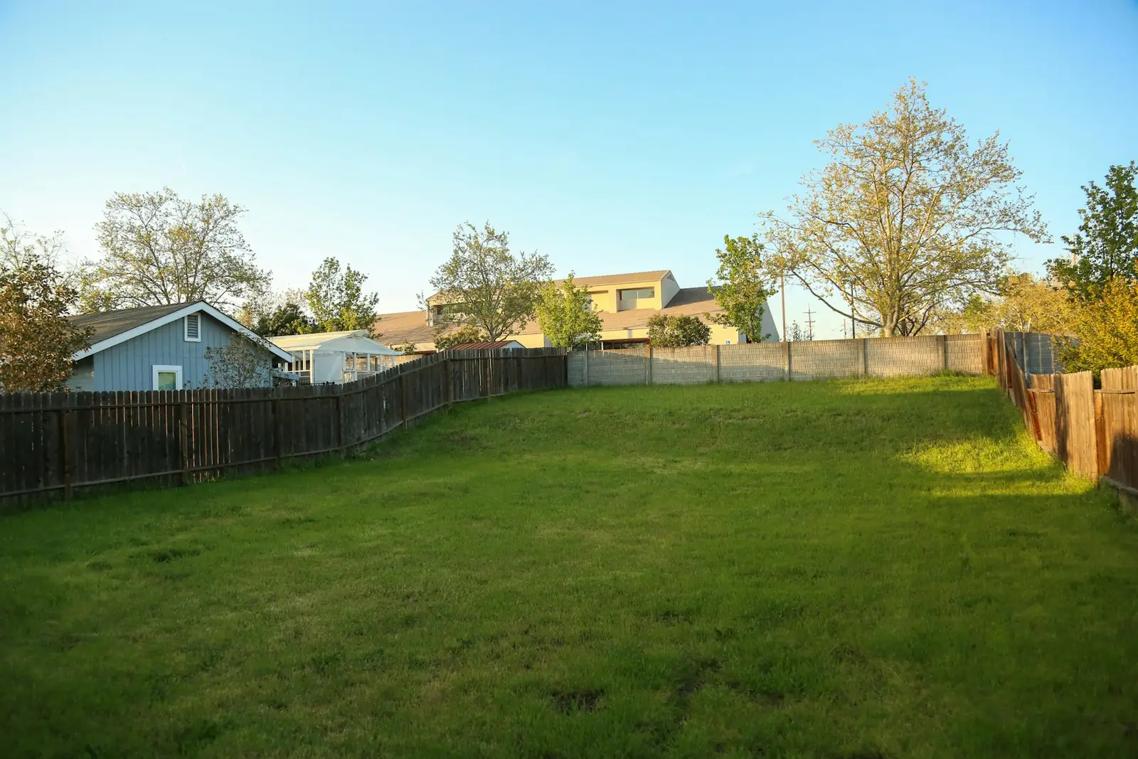 Long back garden lawn with timber boundary fencing
