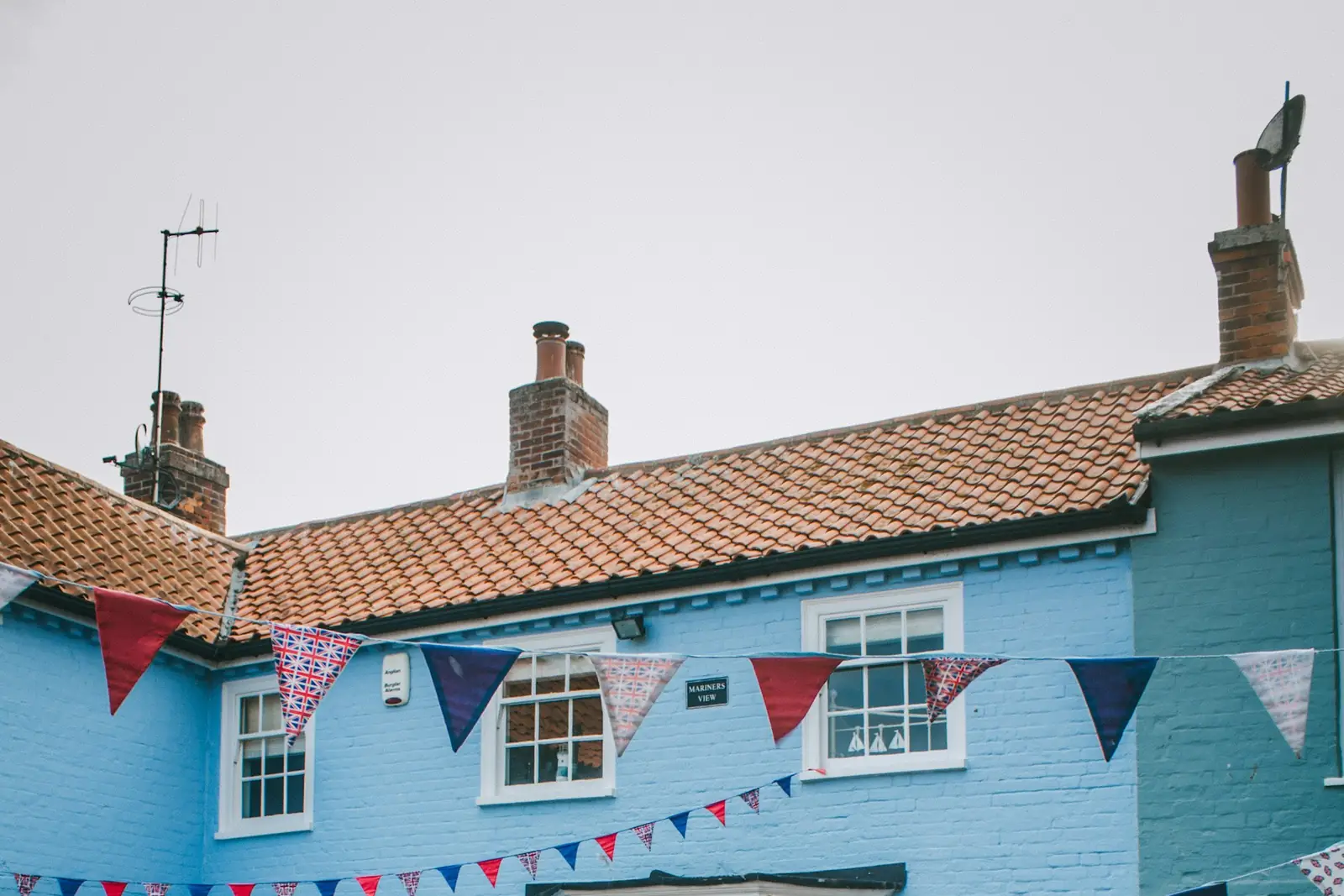 Painted house with a brick garden wall decorated with bunting