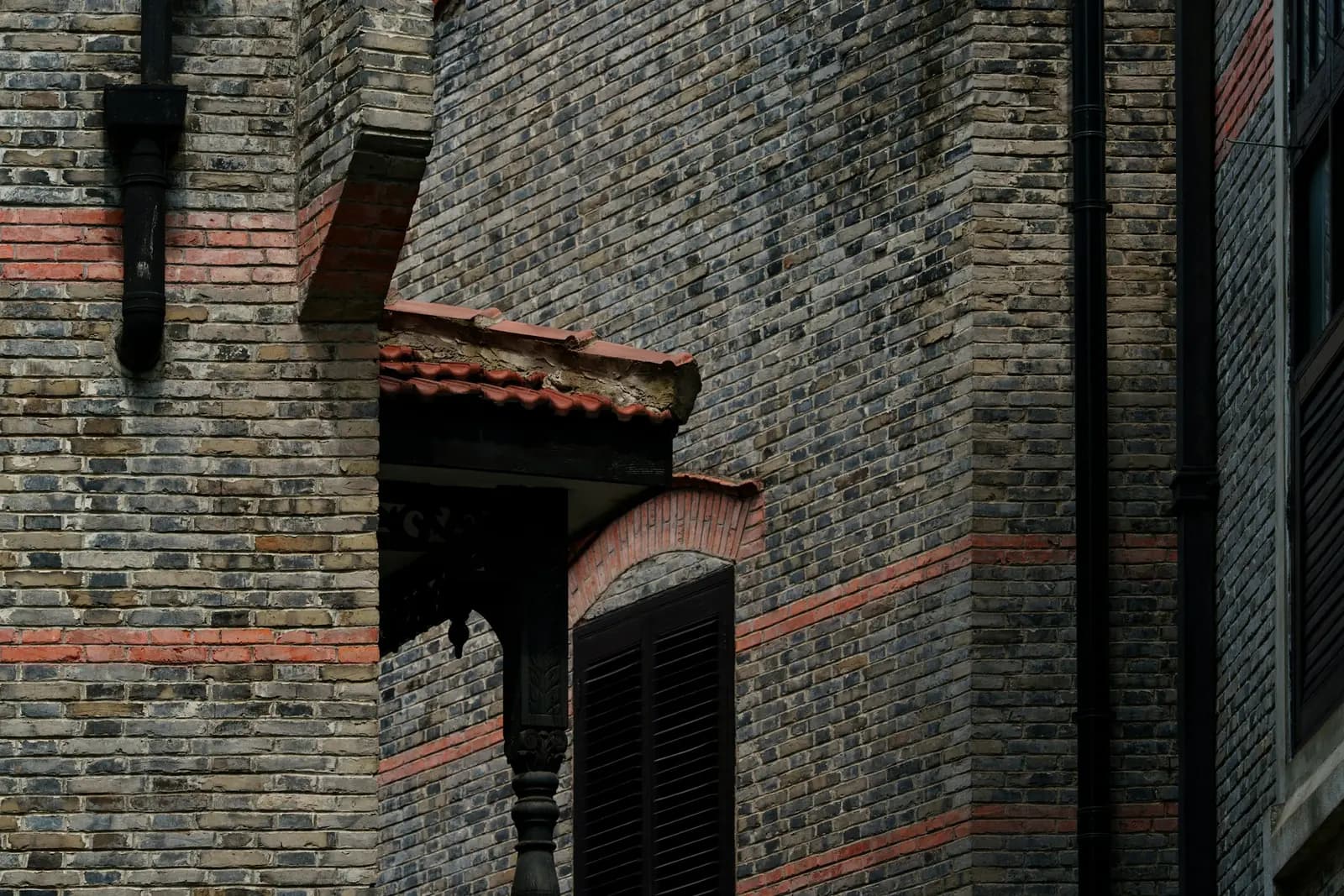 Small pitched canopy above a doorway in a brick wall