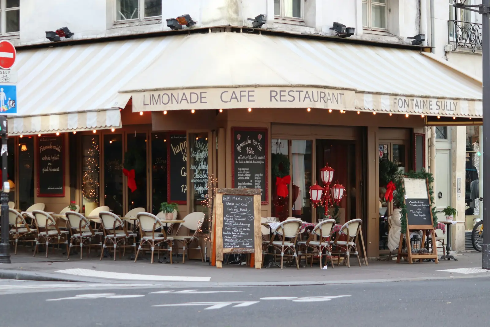 Corner café with a cream awning over its outdoor seating