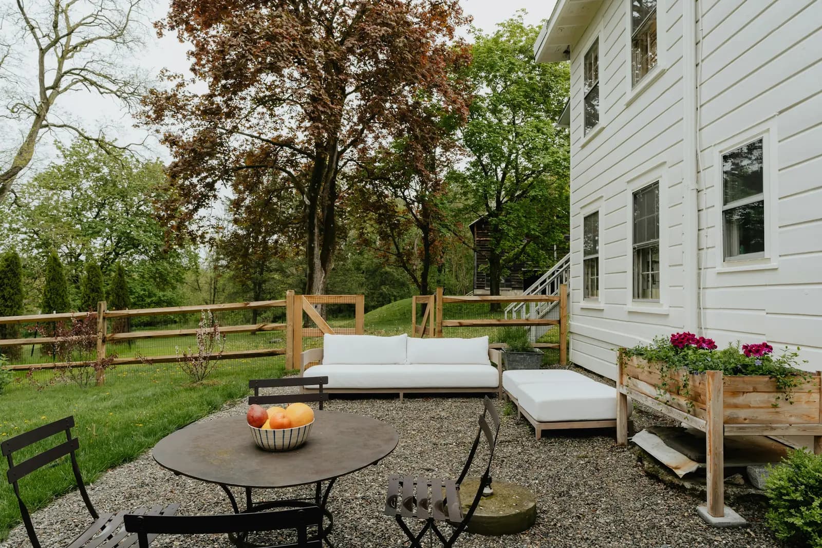 Garden patio with an outdoor sofa, table and chairs beside a house