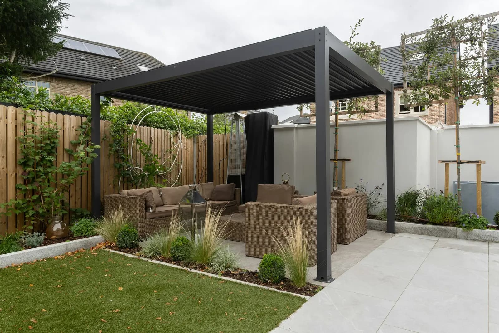 Aluminium louvred pergola over a seating area in a modern garden